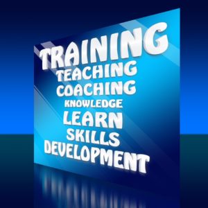 Na zdjęciu znajdują się napisy w języku angielskim na niebieskim tle. Napisy oznaczają: trening, nauczanie, coaching, nauka, umiejętności, rozwój.