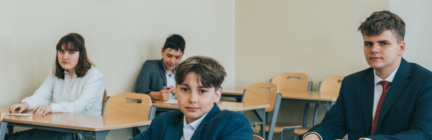 Uczniowie siedzący w ławkach tuż przed rozpoczęciem egzaminu ósmoklasisty.